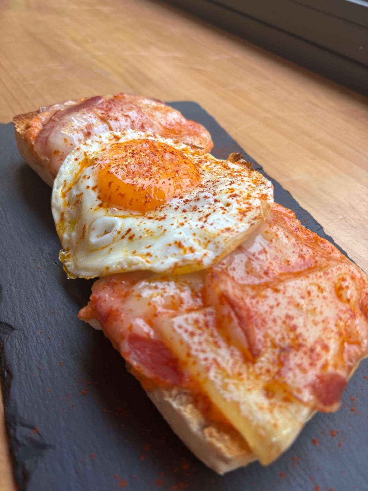 Pan crujiente como las de toda la vida, pero con alma extremeña. Salmorejo suave, queso trufado que perfuma cada bocado y tocino ibérico de Extremadura: jugoso y glorioso. El pimentón de la Vera corona esta tostada con sabor a tierra. Tradición y picardía en cada mordisco. Una tostada que no se anda con rodeos: es pura Extremadura.