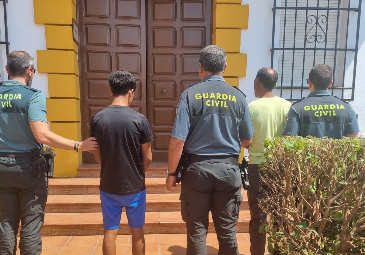Los dos detenidos son custodiados por agentes de la Guardia Civil.