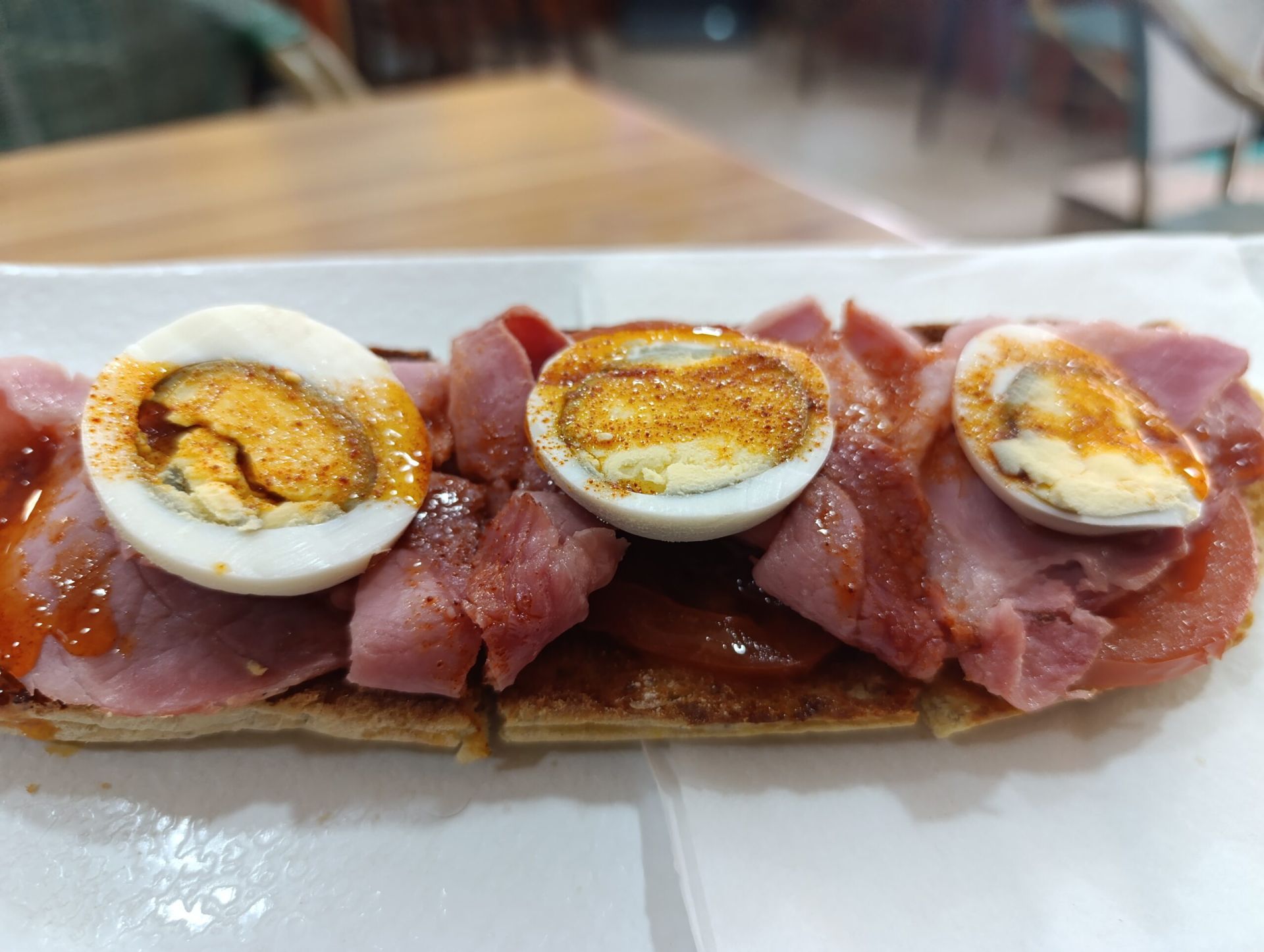 Aceite de pimentón de la vera, con tomate confitado, lacón y huevo cocido en pan de chía, sin gluten, multi cereal y pan común.