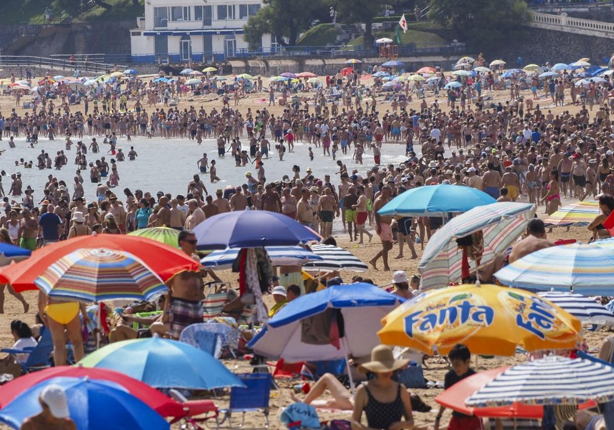 Sombrillas y bañistas en la playa.