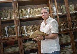 Carlos Sánchez Rubio, archivero municipal de Badajoz, con un libro de actas del siglo XV en las manos.