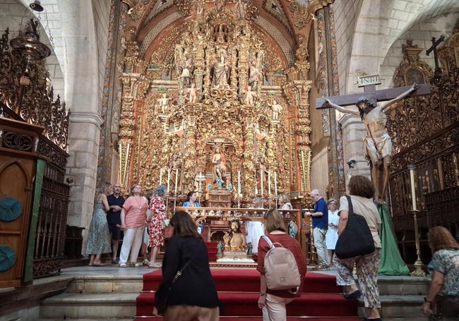 Los visitantes observan con atención el retablo de la