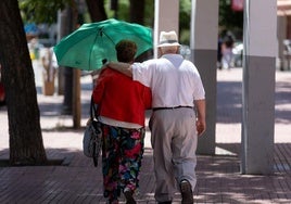 Una pareja de personas mayores pasean junto.