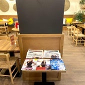 Mesa del café Santagloria con cuatro periódicos a disposición del cliente.