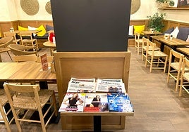 Mesa del café Santagloria con cuatro periódicos a disposición del cliente.