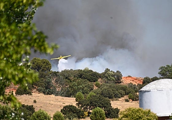 Momento en el que un avión suelta la carga de agua sobre el fuego.