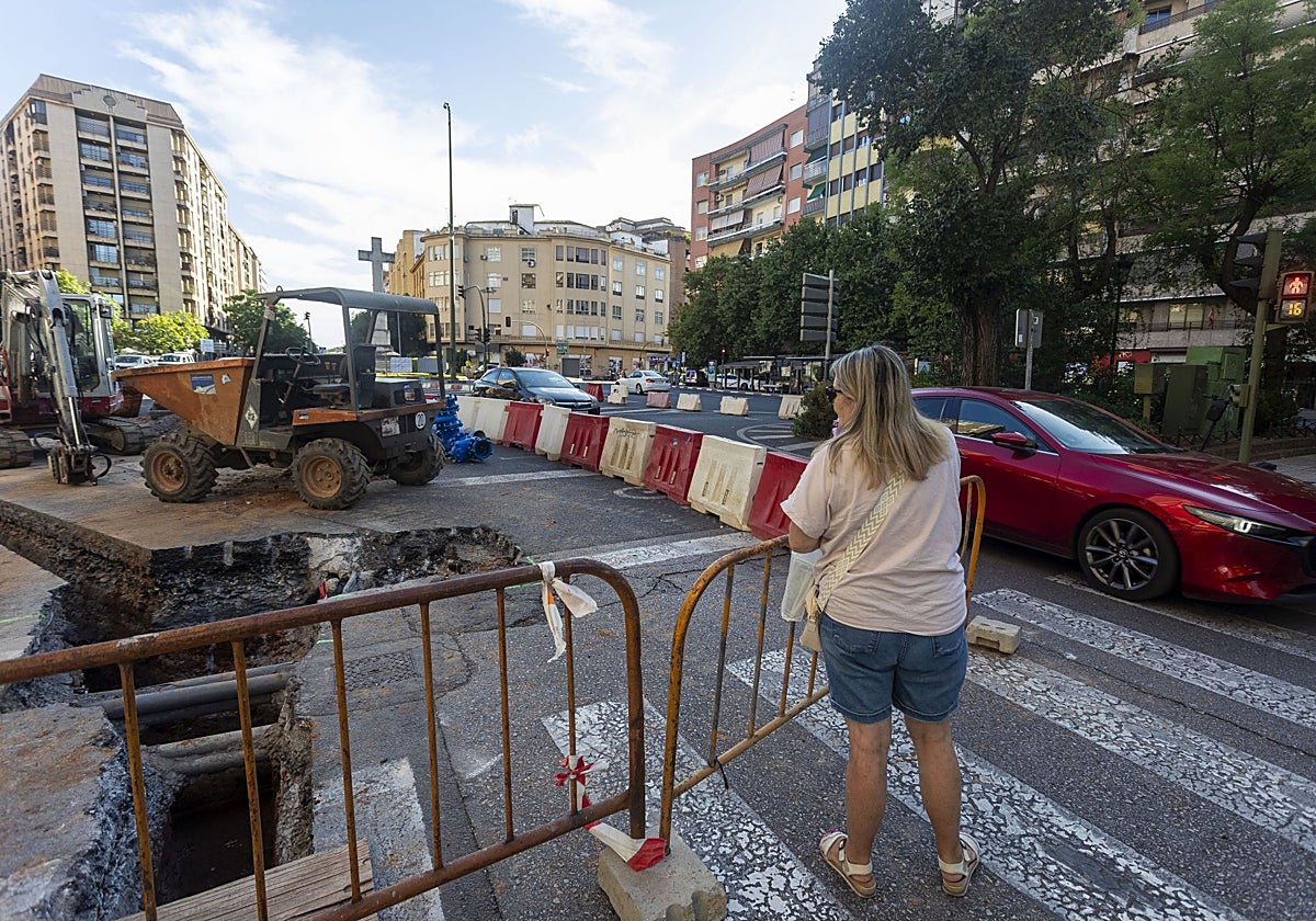 Una cacereña observa las obras desde el paso de peatones del inicio de la avenida España.