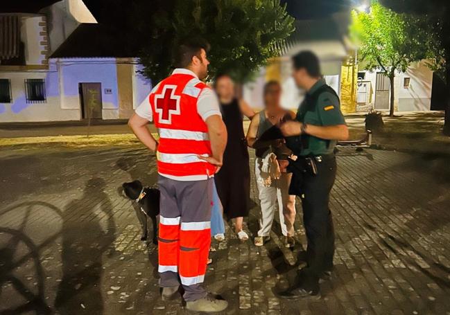 Miembros de Cruz Rojoa y agentes de la Guardia Civil informan a los vecinos del poblado de Cijara.