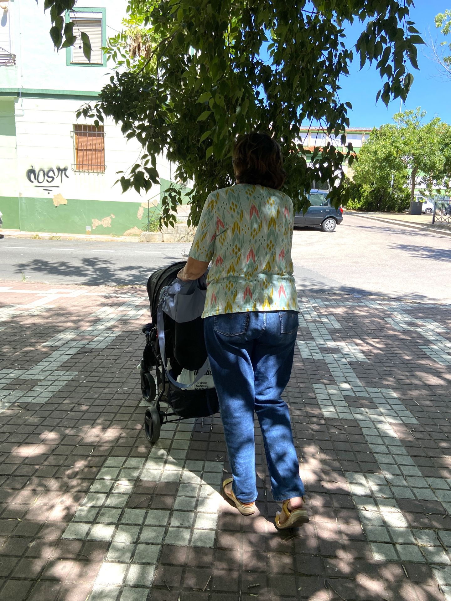 Una madre con su bebé choca con las ramas de un árbol en Cáceres.