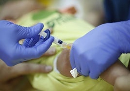 Una enfermera vacunando a un bebé.