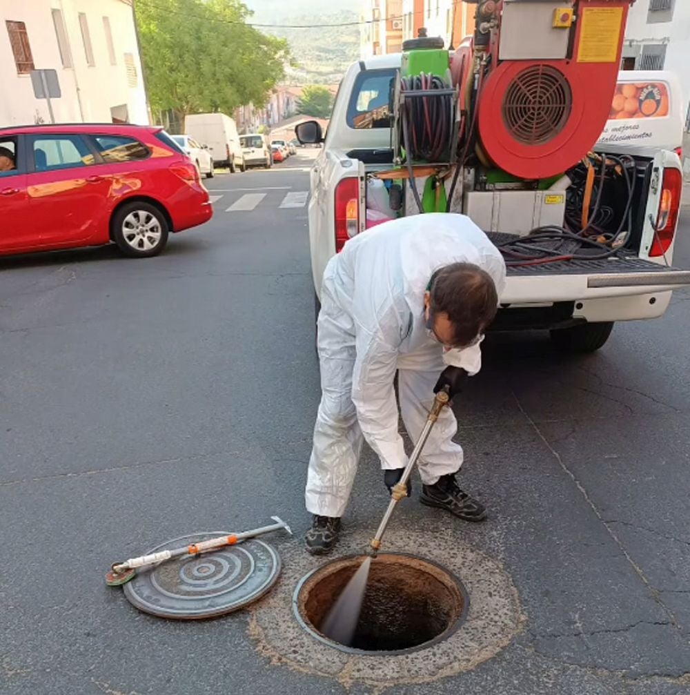 Trabajadores de la empresa fumigan en una de las alcantarillas de Miralvalle.