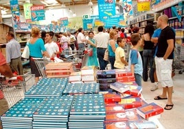 Niños y mayores en la compra de material escolar en un inicio de curso en Mérida.