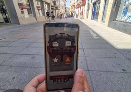 Una persona se dispone a hacer fotos de baldosas en mal estado en la calle Santa Eulalia con la aplicación.