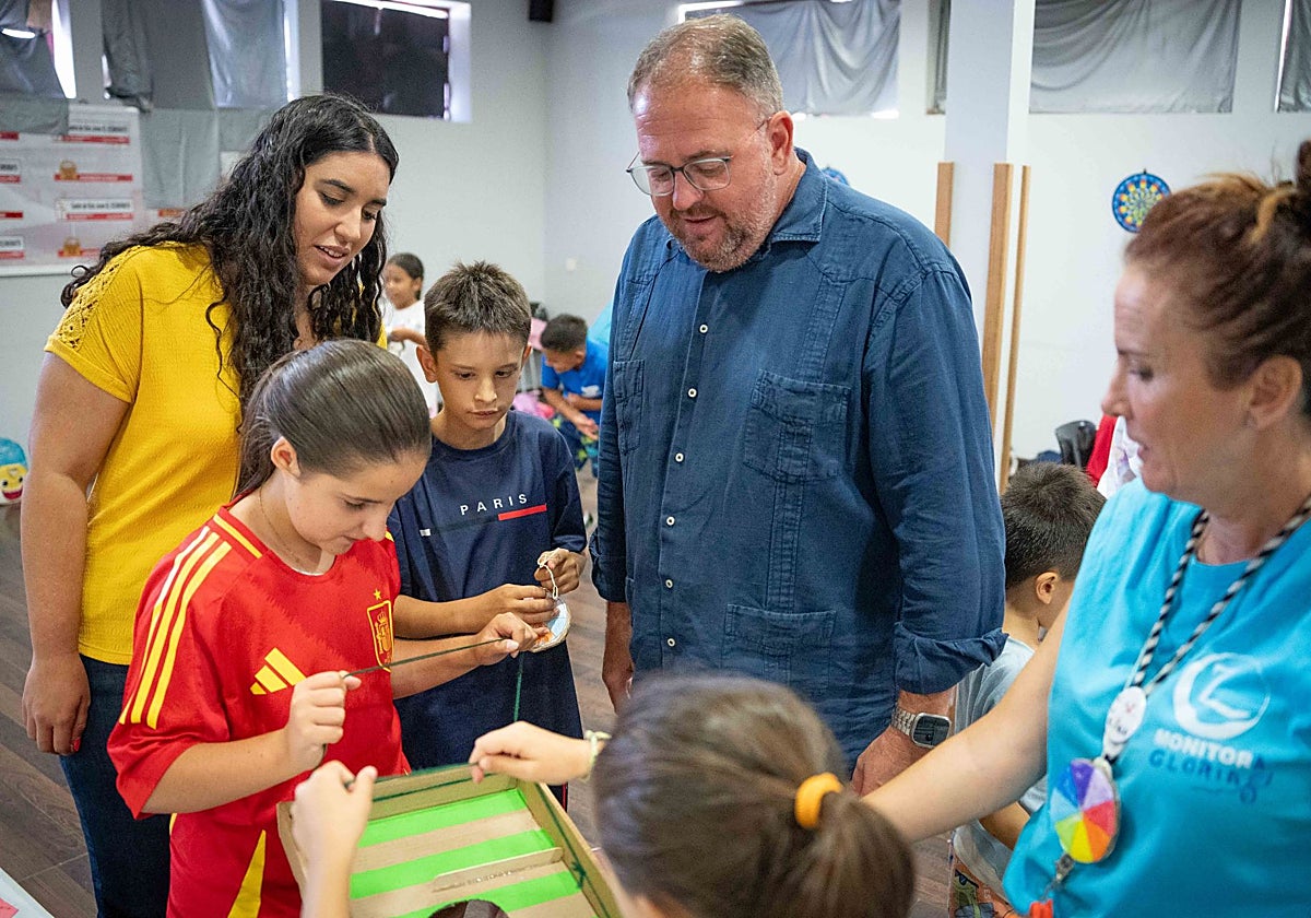 Iglesias y Osuna, junto a niños y una monitora, ayer, en el Economato.