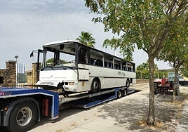 El autobús siendo montado en una góndola para llevarlo a un desgüace.