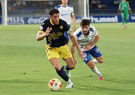 El capitán emeritense, Felipe Alfonso, intenta marcharse del tinerfeño Nacho Gil.