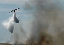 Un hidroavión descarga agua en un incendio.
