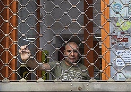 Juan Francisco bajando las persianas de su local en Badajoz.