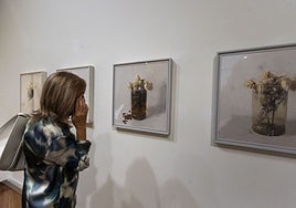 Una mujer contempla la serie 'Rosas de Ávila' del artista Antonio López