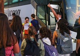 Varios alumnos se suben al autobús que les lleva a su centro educativo.