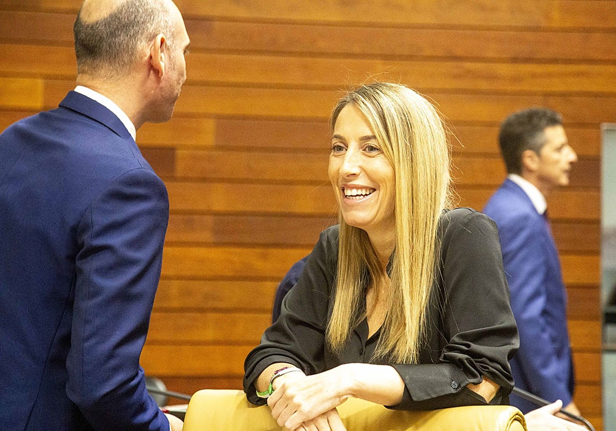 María Guardiola habla en el inicio del pleno con el portavoz del Grupo Parlamentario Popular, José Ángel Sánchez Juliá.