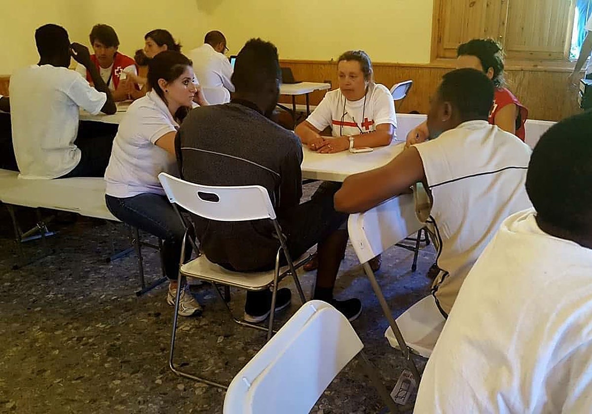 Personal de Cruz Roja con inmigrantes en el centro de acogida temporal de Mérida.