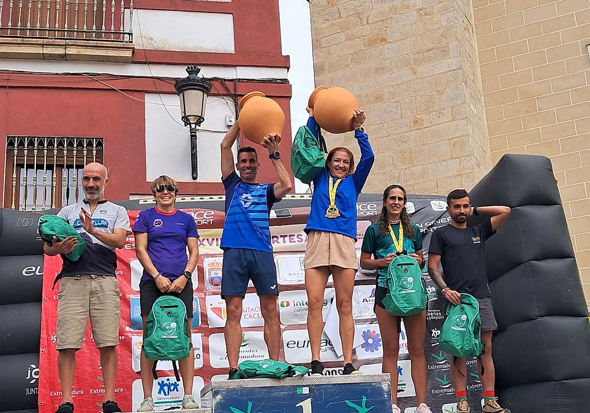 Miguel Madruga y Gema López levantan las tinajas como ganadores del Artetrail y campeones de Extremadura.