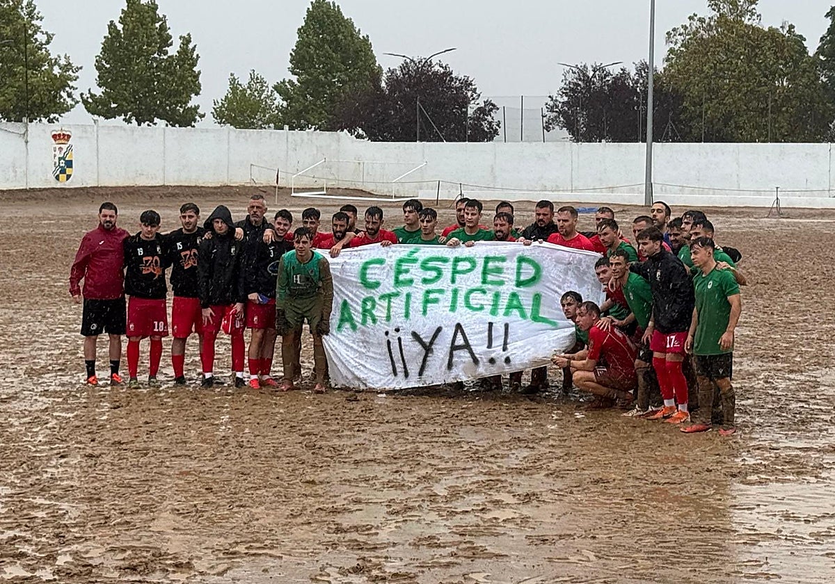 Jugadores del Barbaño y Badajoz B reivindican el césped artificial sobre el barrizal tras suspenderse el partido.