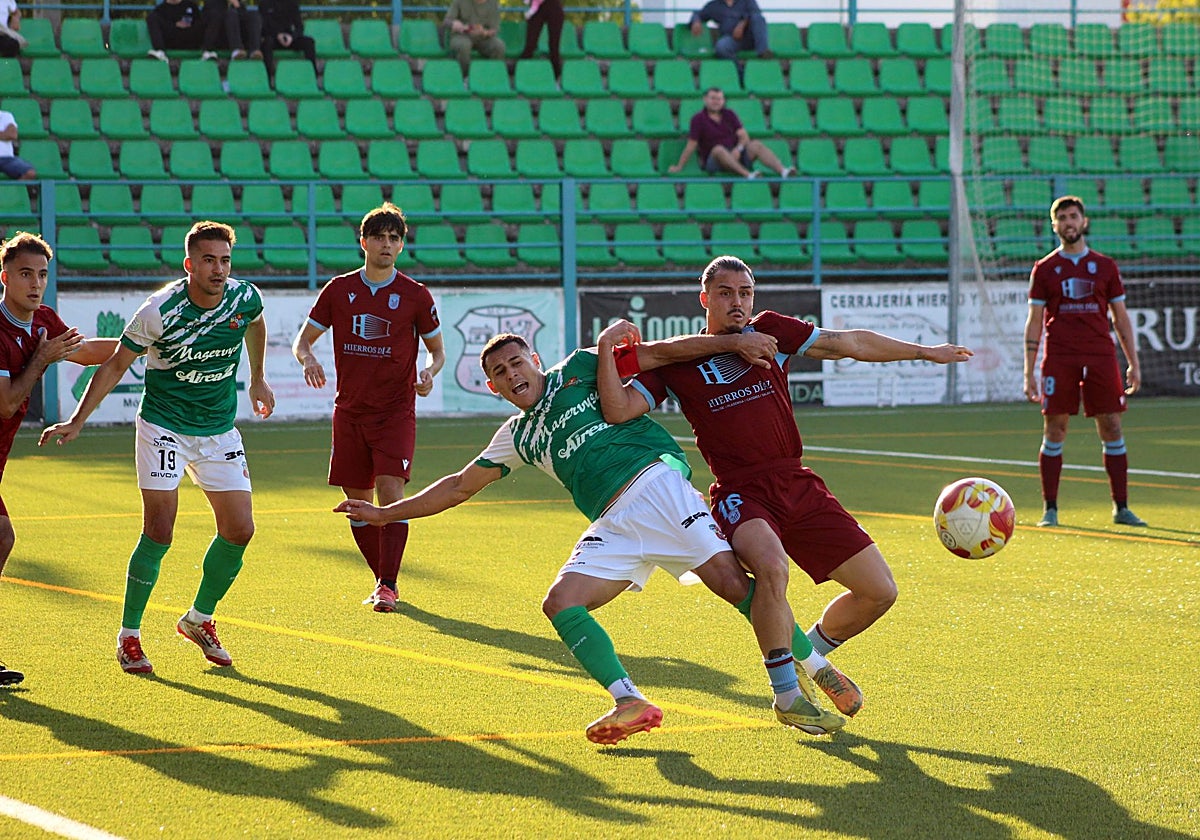 Gustavo Quezada lucha por un balón en el partido del Badajoz con el Moralo.