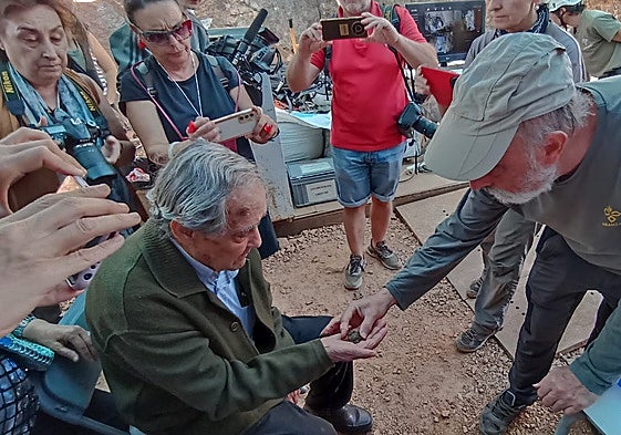 El forense Francisco Etxeberría muestra una moneda a Julio Chaparro, hijo de un represaliado.