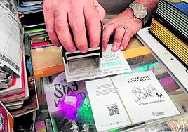 Un comerciante pone su sello a un pasaporte.