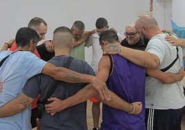 Un grupo de presos se abraza al terminan una sesión de OMtraining en el centro penitenciario de Badajoz.