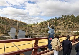 Una vecina fotografía el puente romano de Alcántara desde el nuevo viaducto.