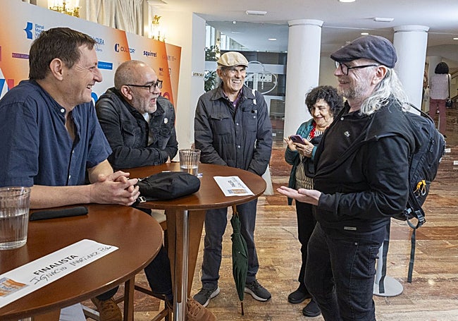 Martínez de Pisón y Gustavo Faverón charlan con el fotógrafo Daniel Mordzinski.