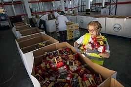 Una voluntaria ordena donaciones en los almacenes de El Nevero.