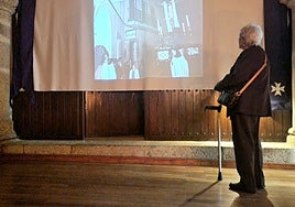 Una mujer contempla una fotografía del Cristo del Calvario, en la sede de la Junta de Cofradías.