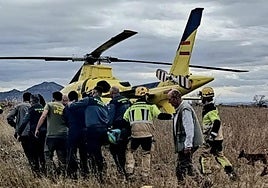 Imagen del traslado del herido en camilla hasta el helicóptero.