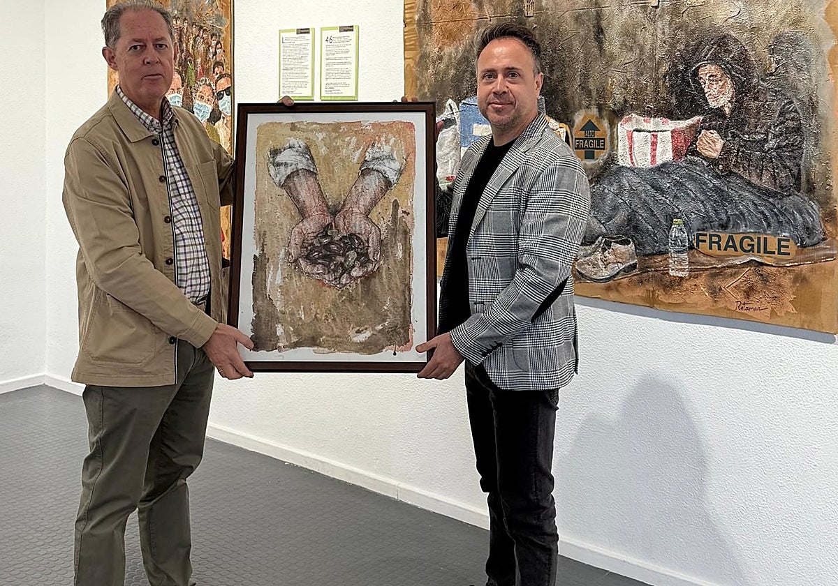 El pintor Damián Retamar dona el cuadro para la gala a Julio González, director de Rotary Mérida.