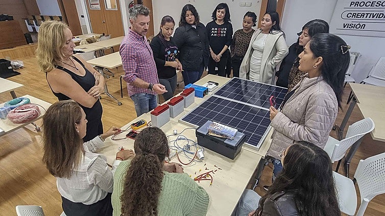 Víctor Corchón, docente del curso, explica a las mujeres el uso de la electricidad y los paneles.