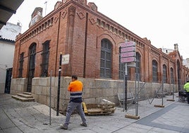 Un operario coloca este viernes una valla junto al edificio una vez que Ferrovial ha iniciado oficialmente la actuación.