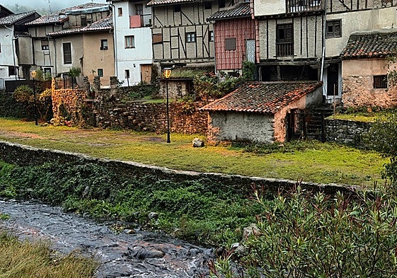 El río Ambroz con ceniza arrastrada tras las lluvias, a su paso por el barrio judío de Hervás.