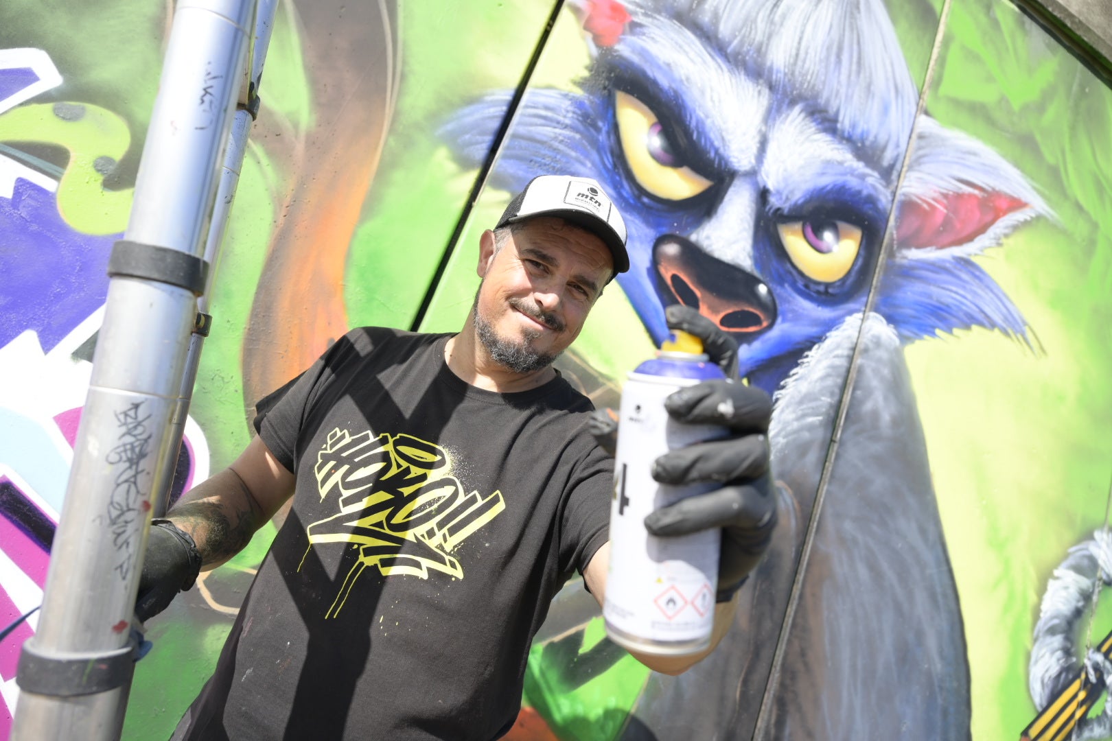 Hoko enseña su herramienta de pintura, un aerosol de colores.