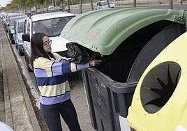 Una pacense deposita una bolsa de basura en la avenida del Diario HOY.