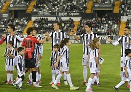 Los chavales de la cantera saltan al césped de la mano de los jugadores del Badajoz antes del comienzo de los partidos.