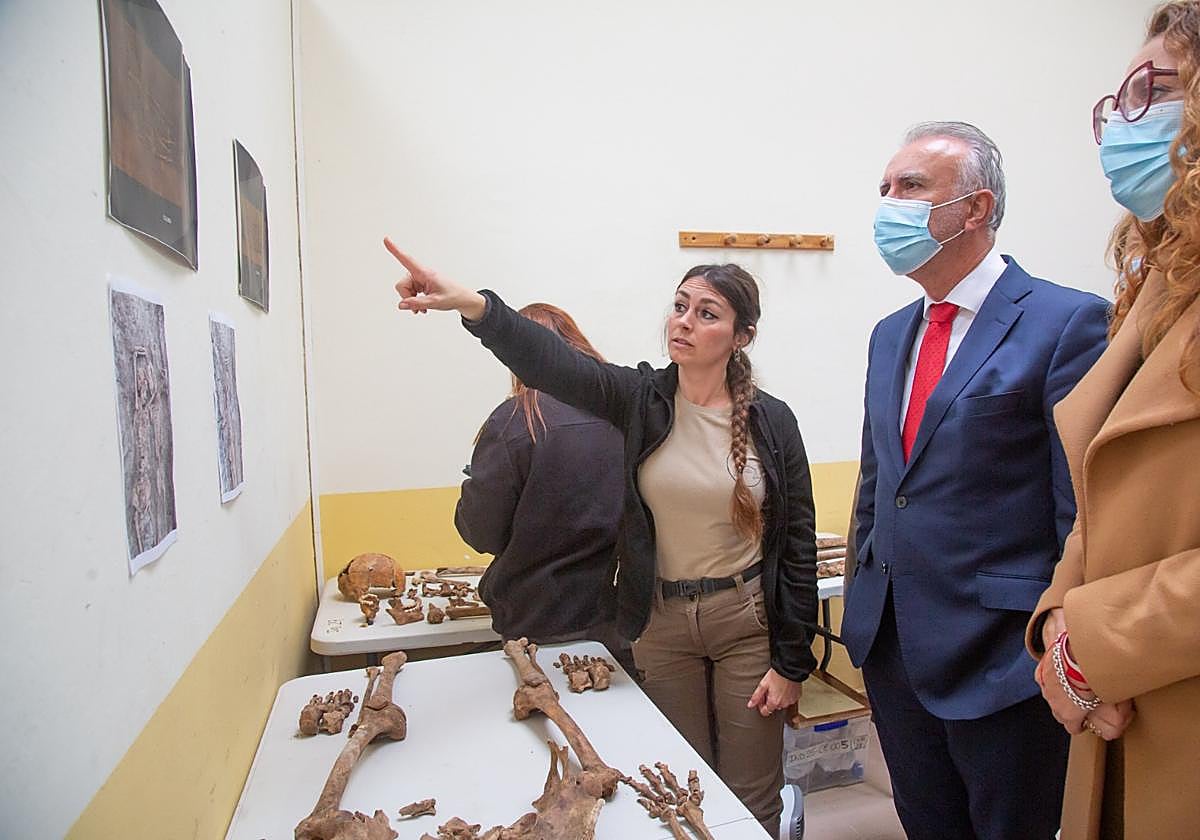 Laura Gutiérrez, directora de la actual intervención en la fosa del cementerio de Villanueva, le explica al ministro Ángel Torres algunos de los hallazgos.