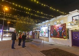 Unas personas hacen fotos a la decoración de una vivienda en la calle Berlanga, de Montealto