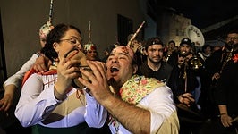 Un peleño bebe de la bota de vino.