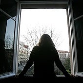 Joven mirando por la ventana en un día nublado