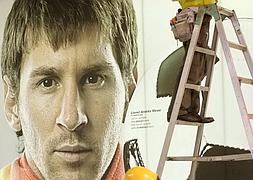 Trabajadores de Tokio colocan un póster de Messi en la capital japonesa en noviembre de 2011/ Shizuo Kambayashi (AP).