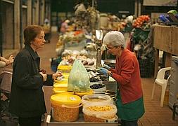 Mujer compra frutos secos en un puesto del mercado de la Ribeira, en Lisboa./ Archivo